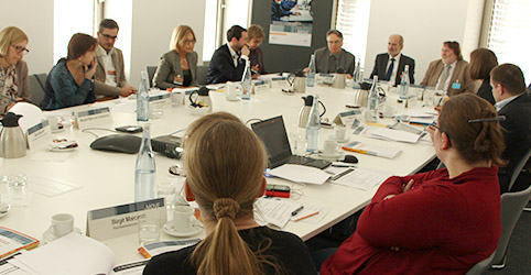 Blick in den Seminarraum auf die Teilnehmer am runden Tisch