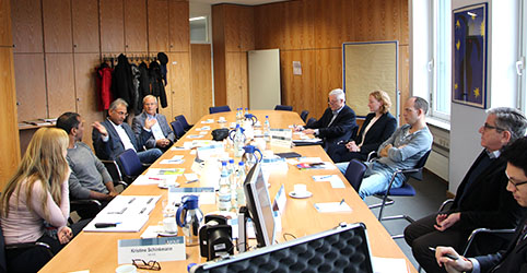 Teilnehmerinnen und Teilnehmer sitzen an einem Tisch