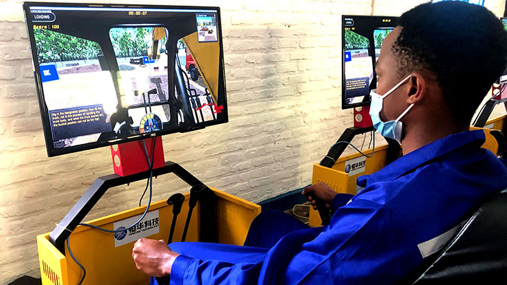 Ruander trainiert das Fahren einer Baumaschine am Simulator