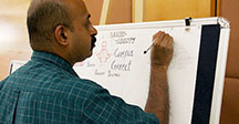 man from India writing on a board