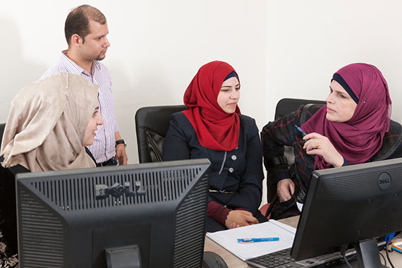 three Arab women working at computers
