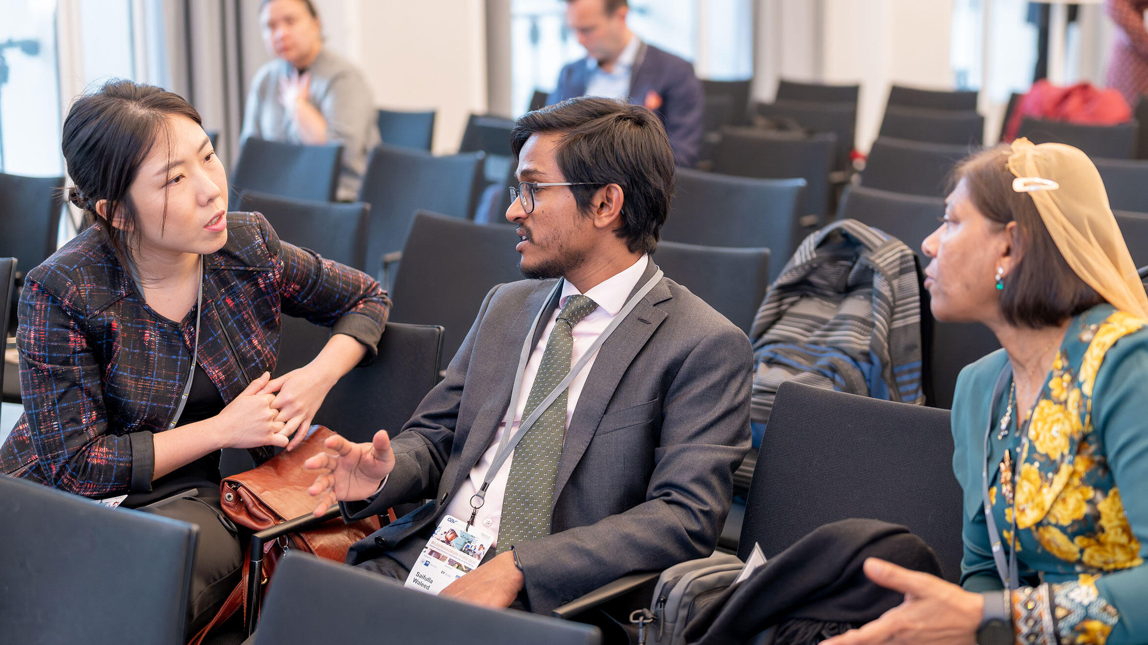 drei Personen sitzen beisammen im Gespräch