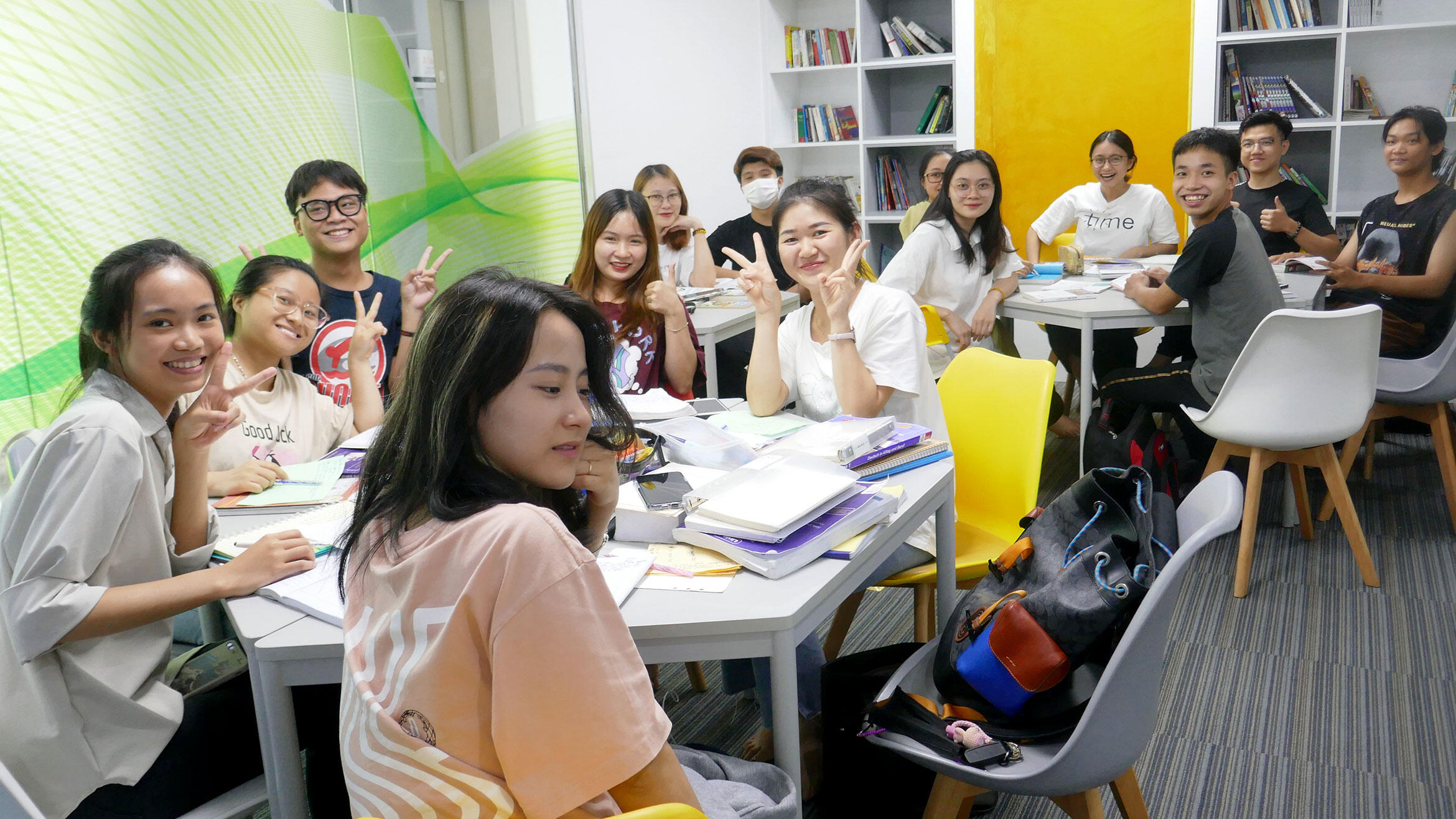 junge Vietnamsinnen und Vietnamesen in einem Klassenraum lachen in die Kamera
