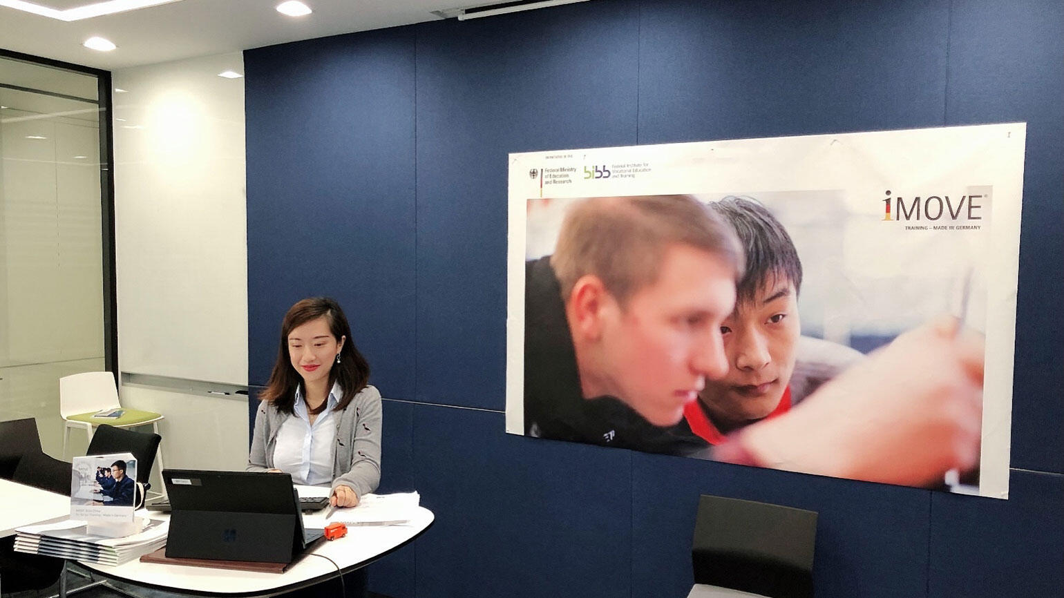 chinesische Kollegin sitzt vor einem Screen