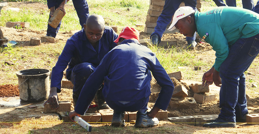 im Trainingszentrum, mehrere Afrikaner arbeiten im Baugewerk