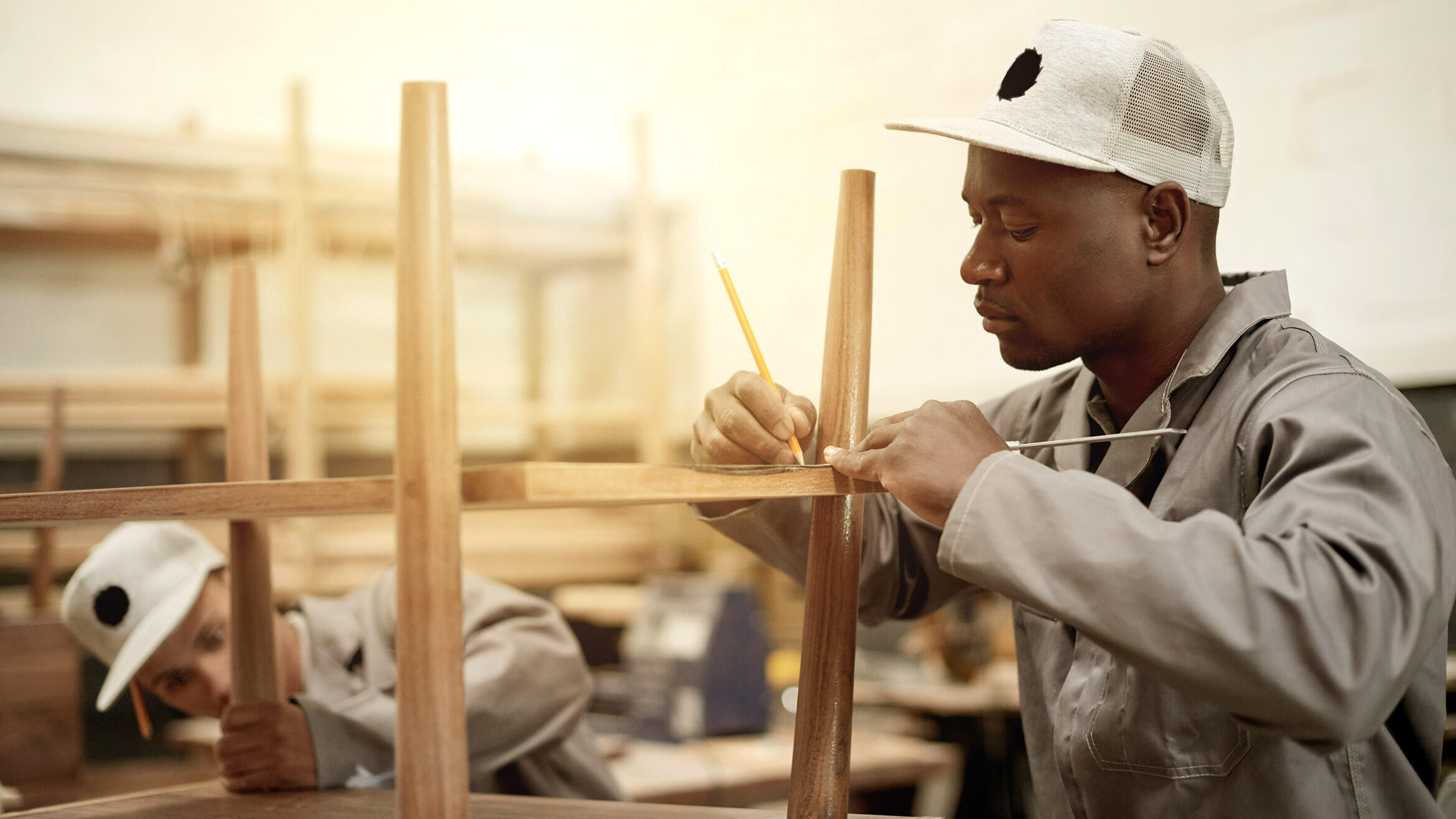 mutmaßlich afrikanischer Schreiner arbeitet an Möbelstück