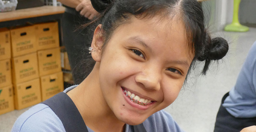 junge Thailänderin lächelt in die Kamera