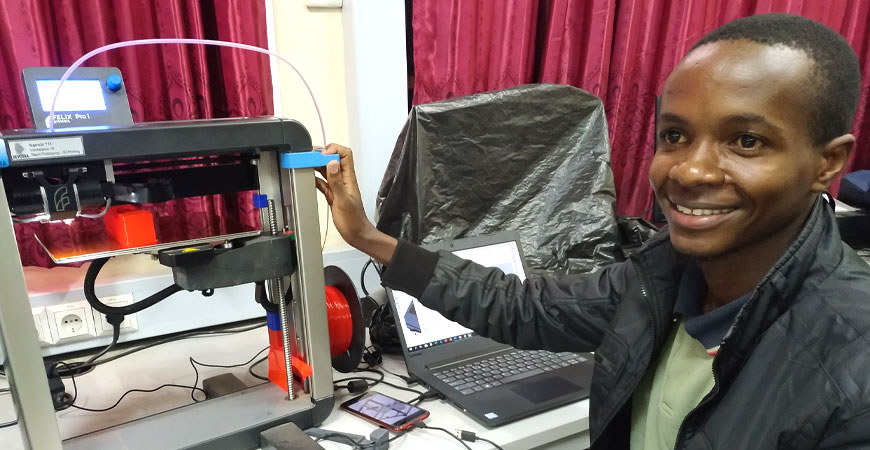 Kenianer sitzt am 3D-Drucker