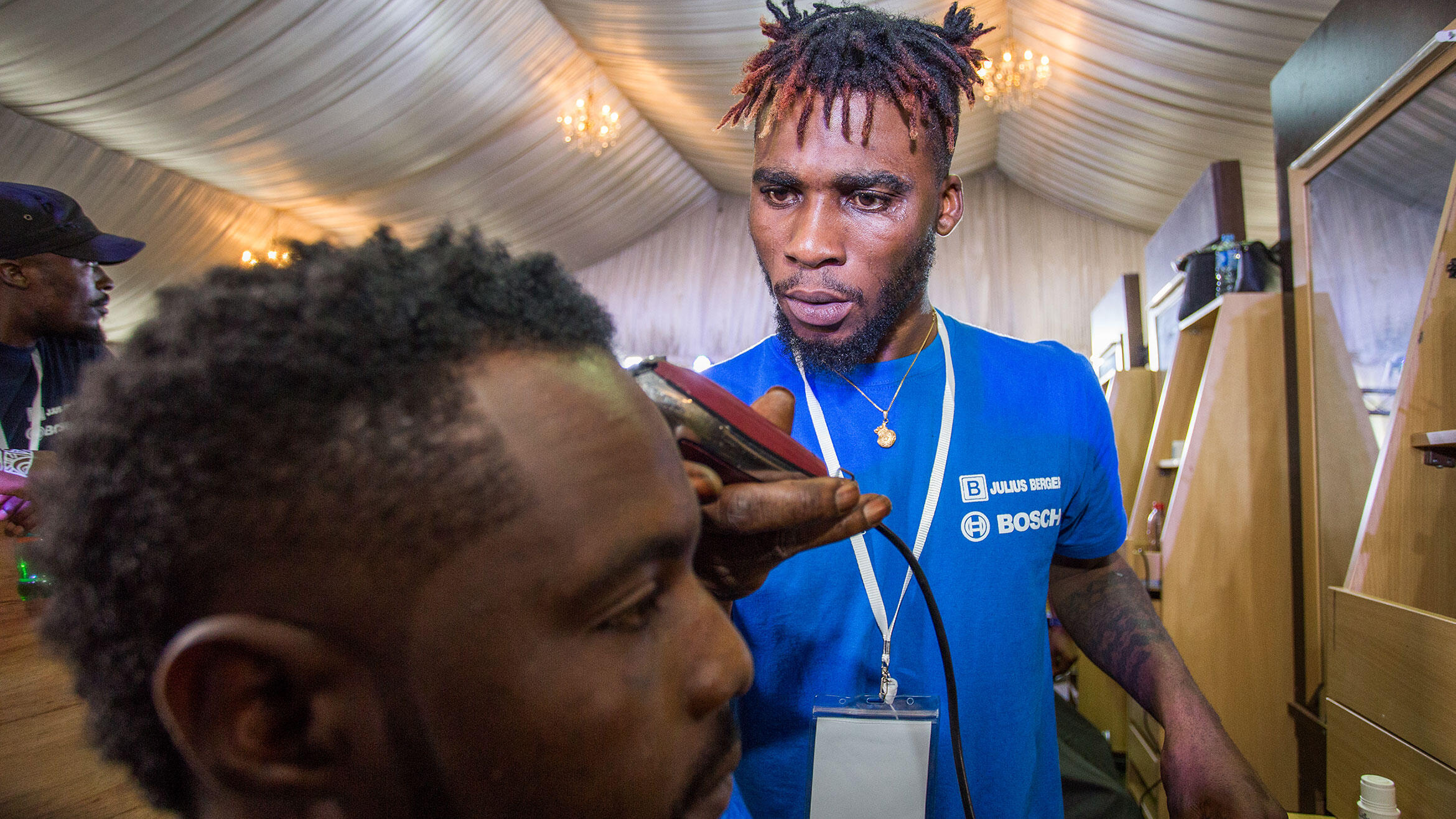 junger Nigerianer schneidet einem zweiten Nigerianer die Haare