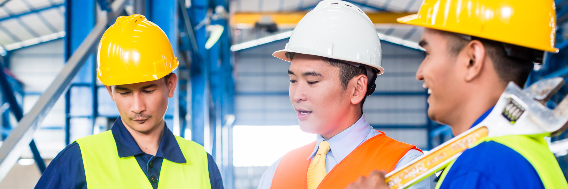 drei Männer mit Schutzhelmen und Sicherheitskleidung