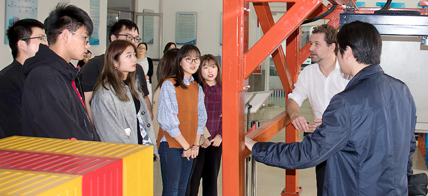 chinesische Schülerinnen und Schüler hören einem Ausbilder zu