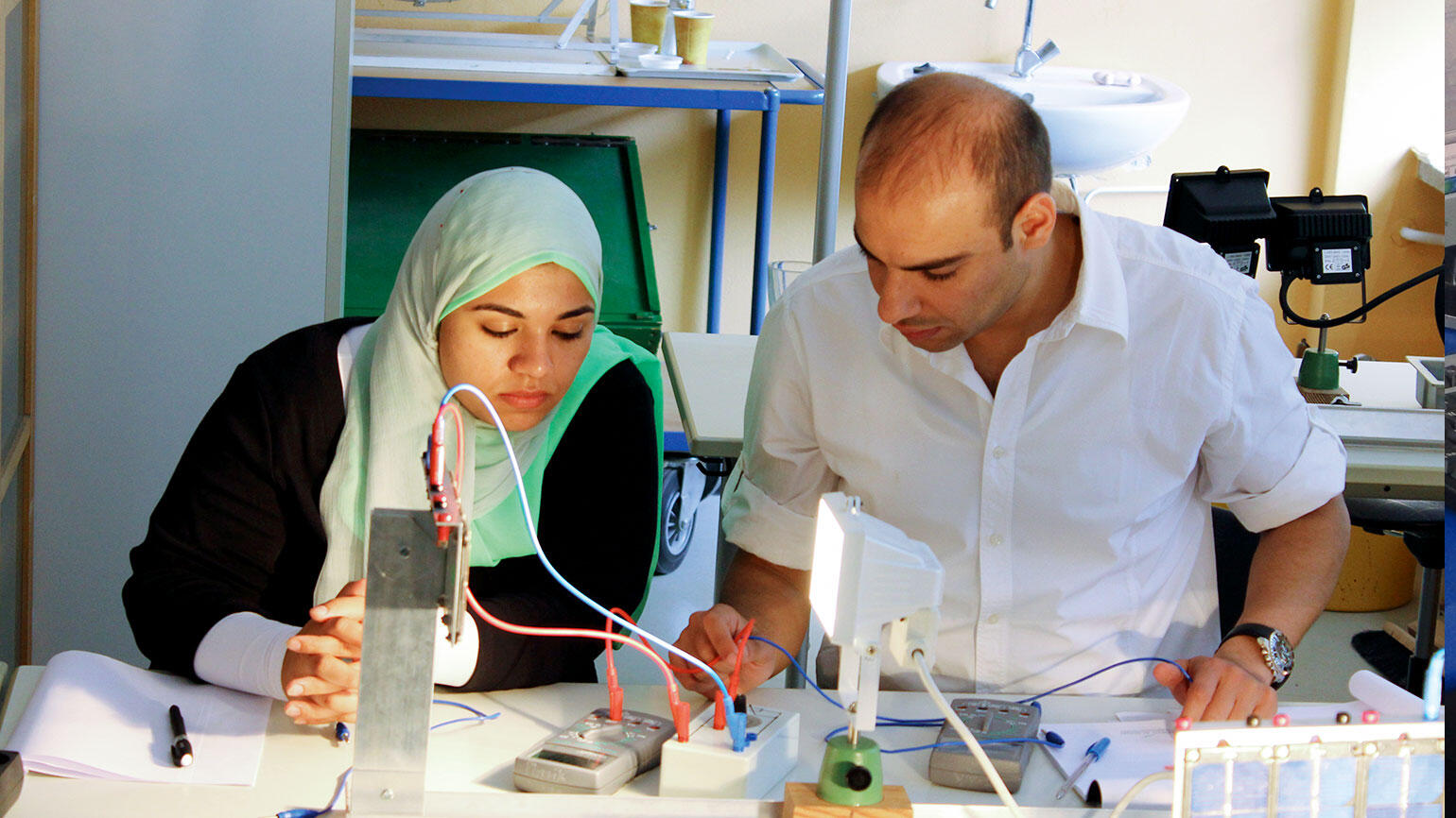 Frau und Mann - mutmaßlich aus einem arabischen Land - arbeiten an einer elektrischen Installation
