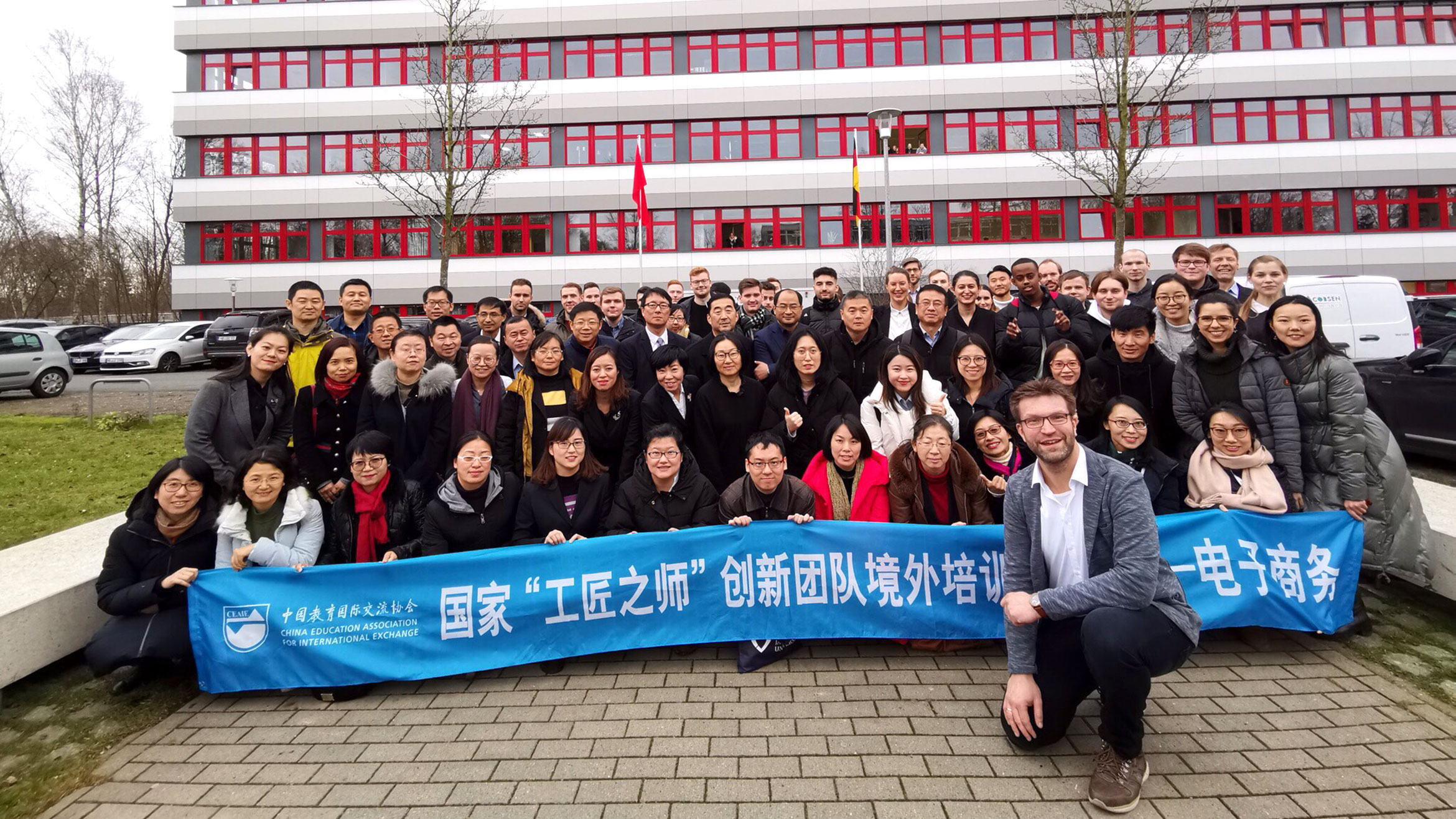 Gruppenbild, erste Reihe hält chinesischsprachigen Banner