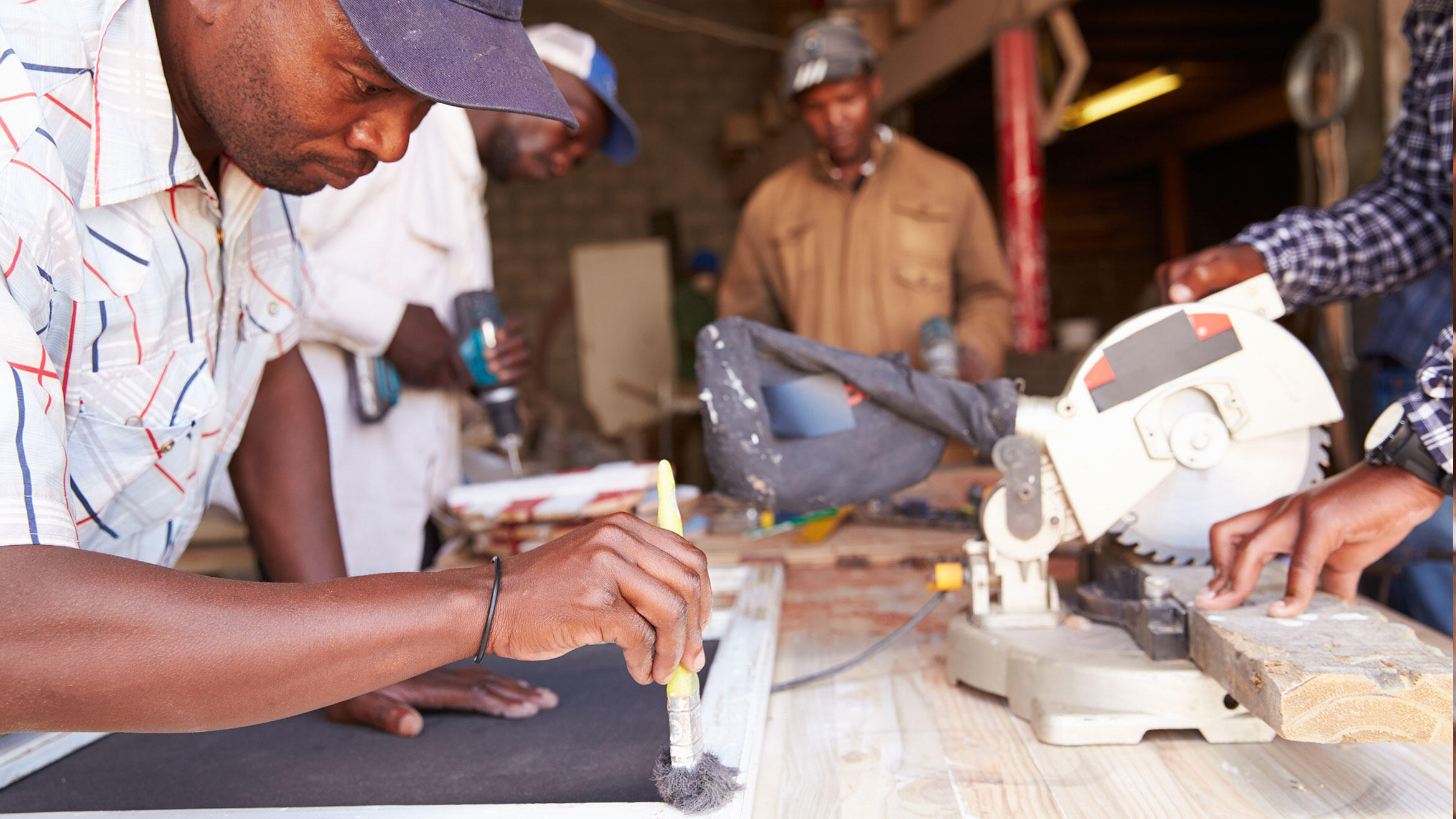 mutmaßlich afrikanischer Mann arbeitet in Holzwerkstatt