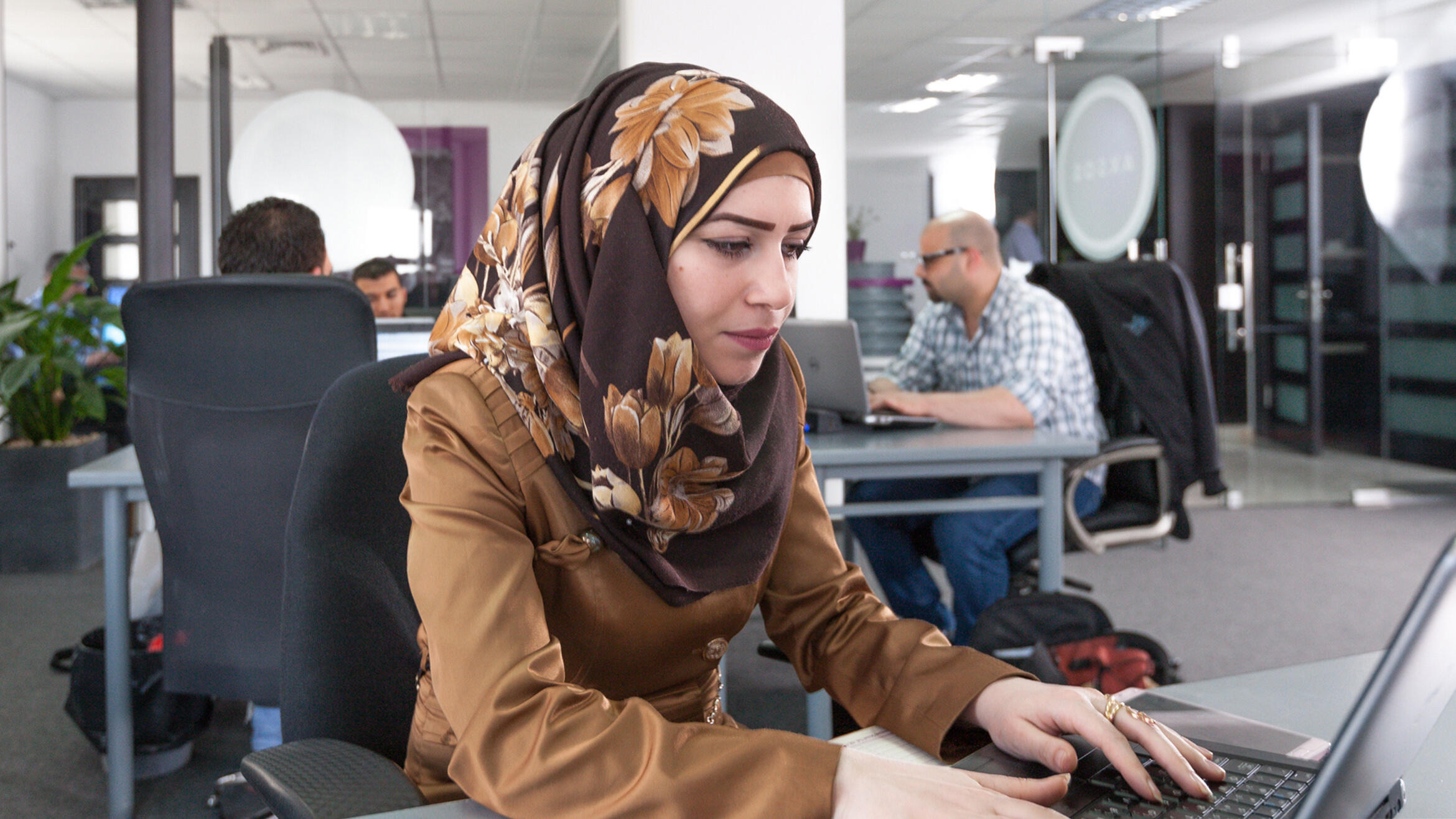 mutmaßlich arabische Frau arbeitet an einem Laptop