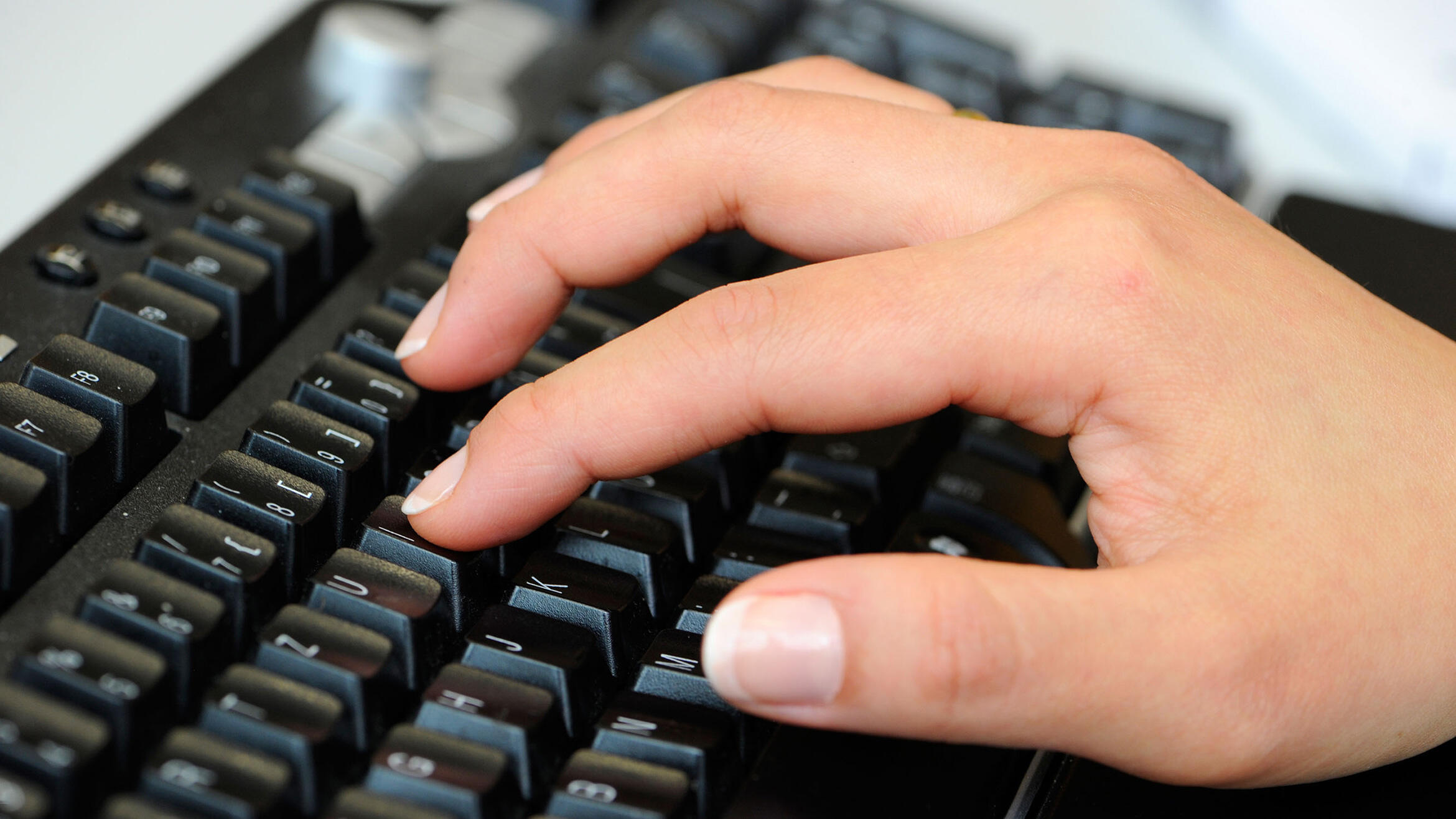 Detailansicht: Hand auf Tastatur