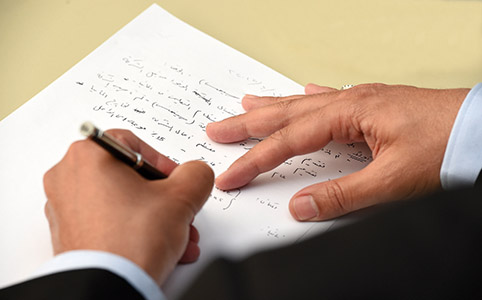 Detailaufnahme: Hände schreiben etwas auf Arabisch