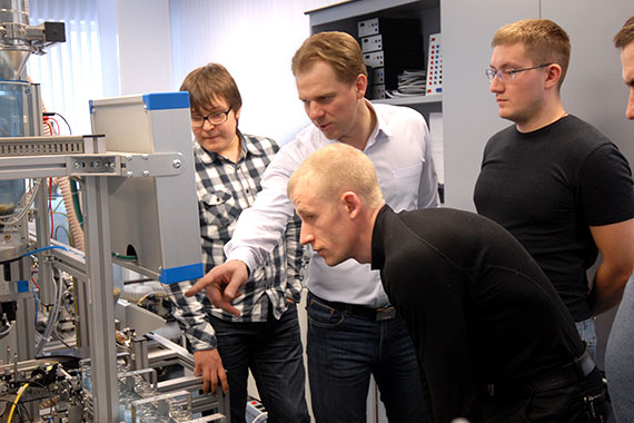 mehrere Männer sehen sich eine technische Installation an