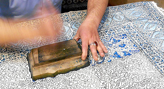 Detailansicht: handwerkliches Färben eines Teppichs mit Holzstempel