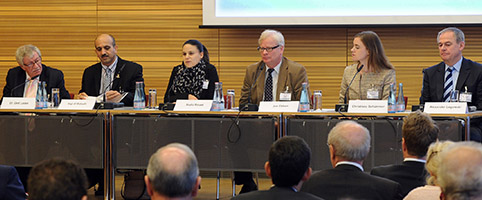 Teilnehmerin, Teilnehmer und Leiterin der Session auf dem Podium