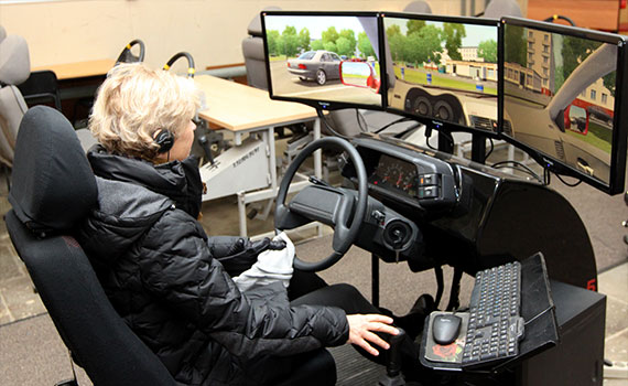 Frau sitzt in Fahrsimulator