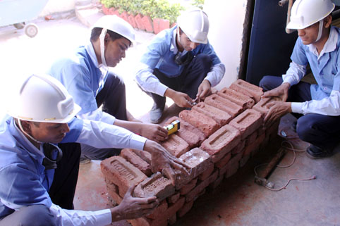 Auszubildende arbeiten an Mauer