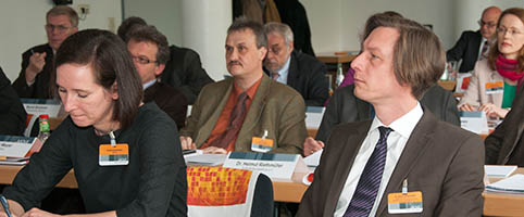 Mehrere Seminarteilnehmerinnen und Teilnehmer an Tischen