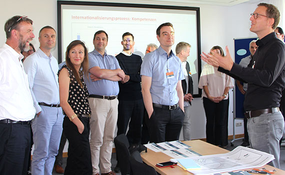 Referent steht vor Teilnehmer-Gruppe des Workshops