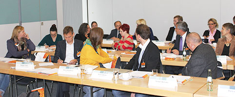 Blick in den Raum, die Teilnehmer drehen sich zu einer Sprecherin aus ihren Reihen
