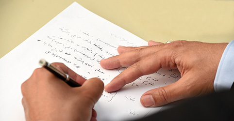 Detailansicht: Hände, die Arabisch schreiben