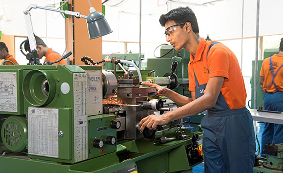 junger Inder arbeitet an Fräsmaschine