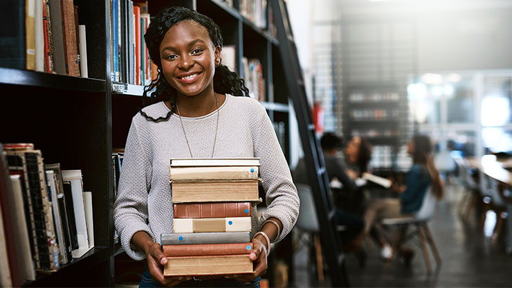 junge Afrikanerin trägt Bücher in den Händen