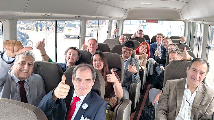 Delegationsteilnehmende sitzen in Bus und zeigen Daumen hoch