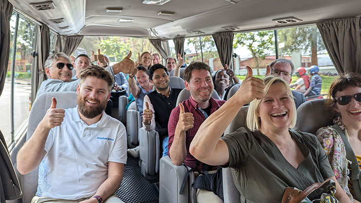 Menschen in einem Bus heben die Hände mit erhobenem Daumen