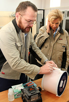zwei Personen arbeiten an einer Kabeltrommel