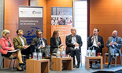 Diskutanten sitzen auf dem Podium bei einer Paneldiskussion