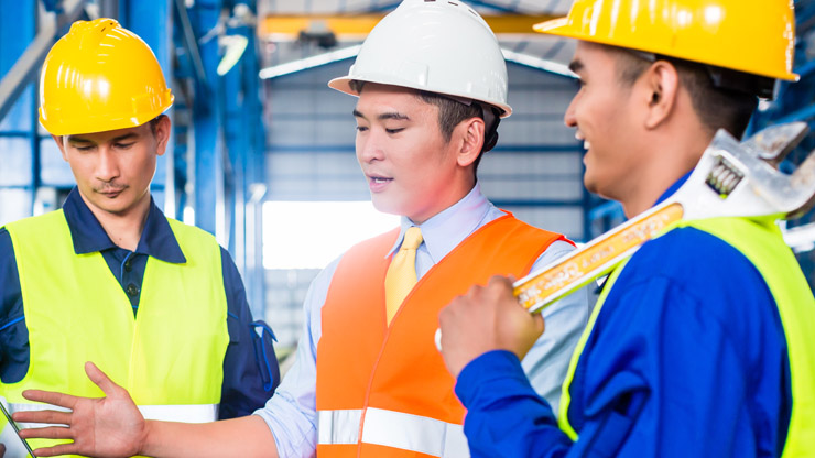 drei Männer mit Schutzhelmen und Sicherheitskleidung