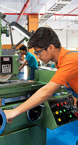 indischer Auszubildender arbeitet an CNC-Fräsmaschine
