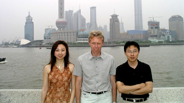 drei Personen vor Skyline einer chinesischen Stadt