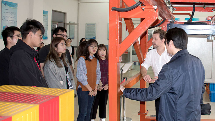 chinesische Schülerinnen und Schüler hören einem Ausbilder zu