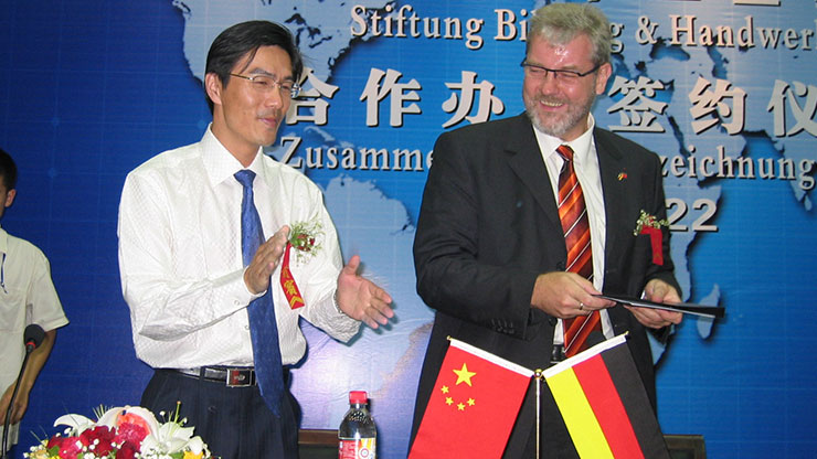 Chinese und Deutscher bei einer Unterschriftenzeremonie