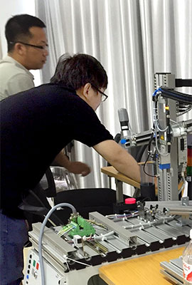 zwei chinesische Fortbildungs-Teilnehmer arbeiten an einer Apparatur