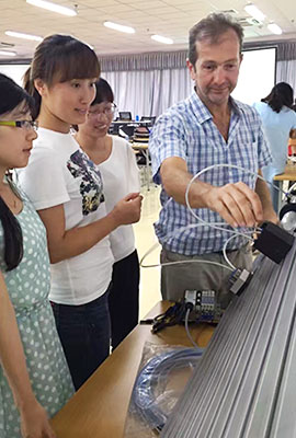 deutscher Ausbilder mit drei Fortbildungs-Teilnehmerinnen aus China