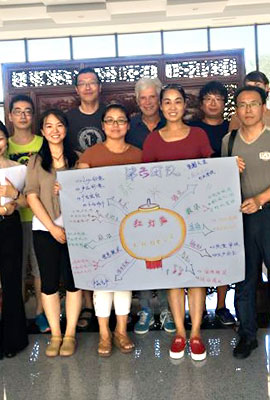 Gruppenbild chinesischer Absolventen einer Fortbildung präsentiert ein Plakat