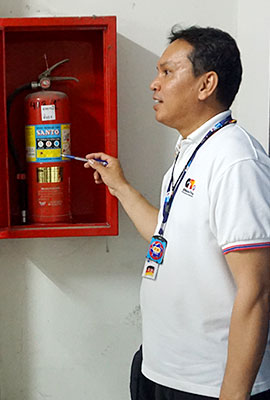 Thai zeigt auf einen Feuerlöscher