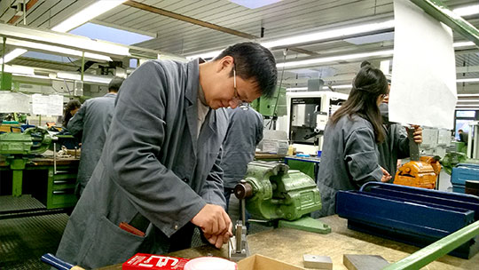 chinesische Lehrkraft arbeitet in Lehrwerkstatt