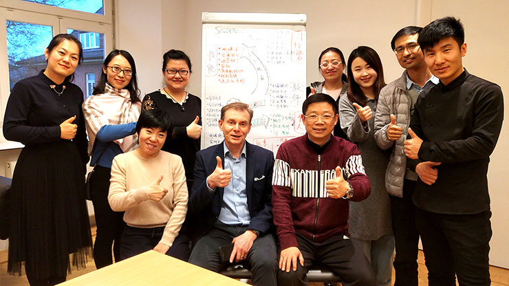 Gruppenbild: chinesische Berufsschullehrkräfte mit deutschem Trainer in einem Klassenraum