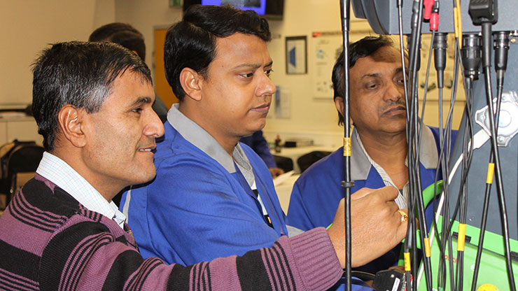 Drei indische Ausbildungsleiter beim Training an einer technischen Anlage