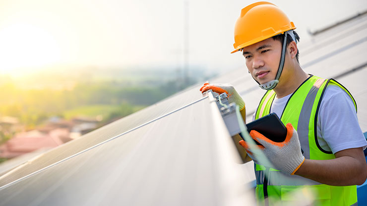 junger Asiate überprüft Solarmodule