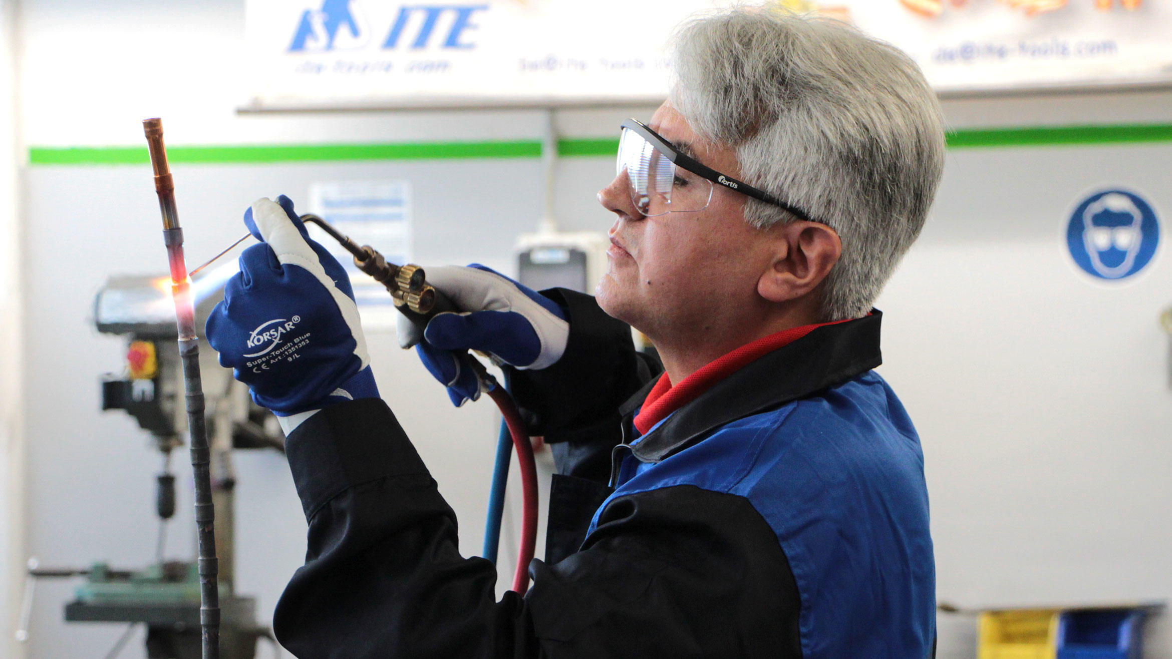 trainer from Iran welds a pipe